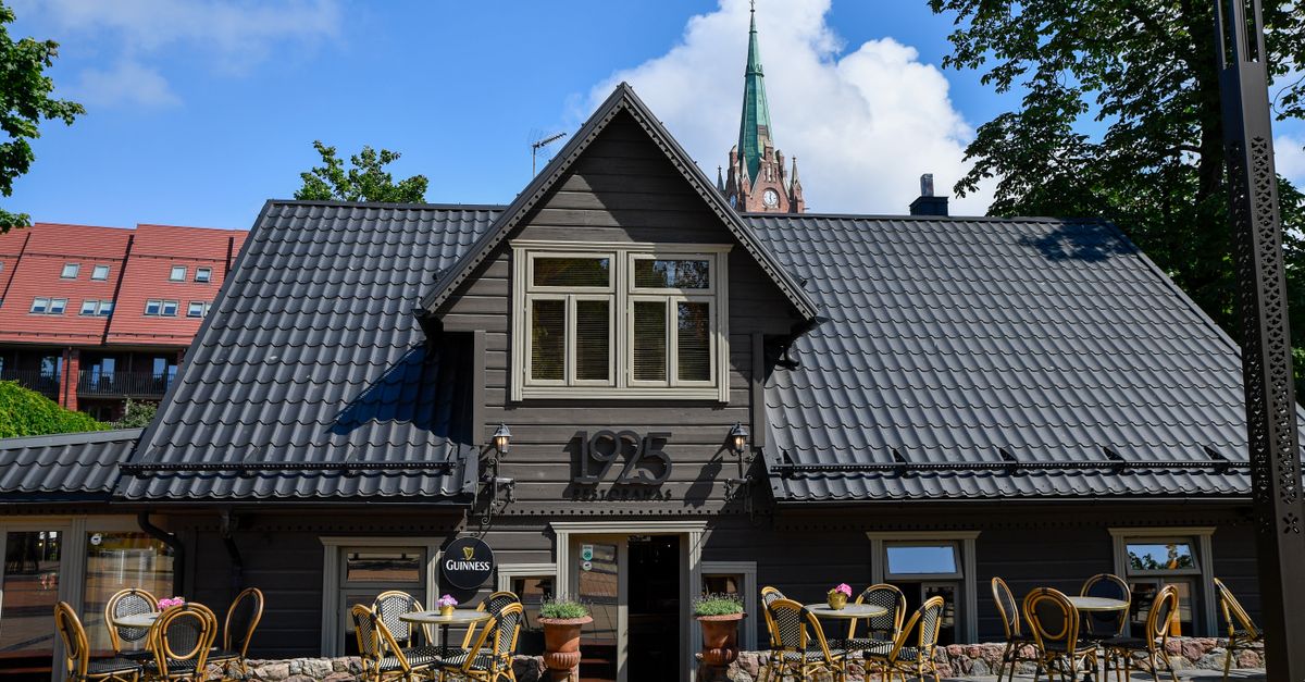 Cozy outdoor seating at a historic Lithuanian cafe with Neo-Gothic elements.