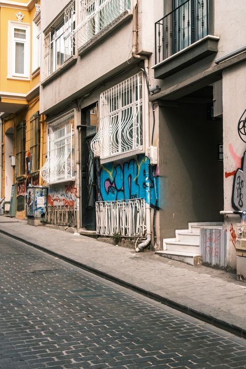 Free A vibrant urban street scene with graffiti and historic architecture, perfect for modern city themes. Stock Photo