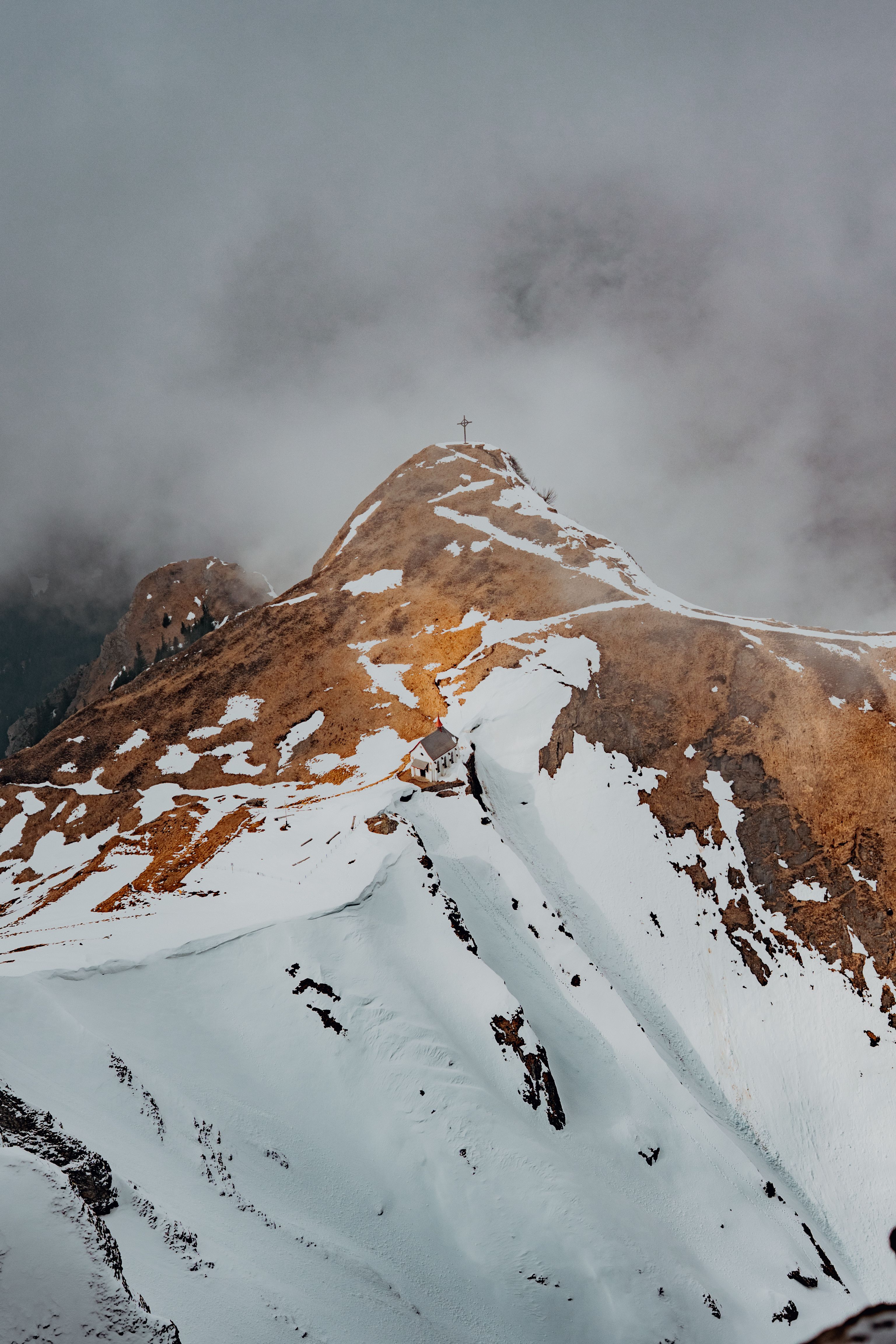 Majestic snowy mountain peak with foggy skies in Hergiswil, Switzerland.