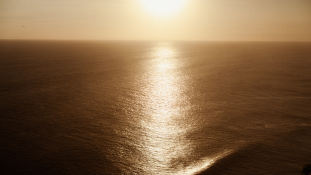 A breathtaking view of the golden sunset reflecting off the ocean near Bali, Indonesia.