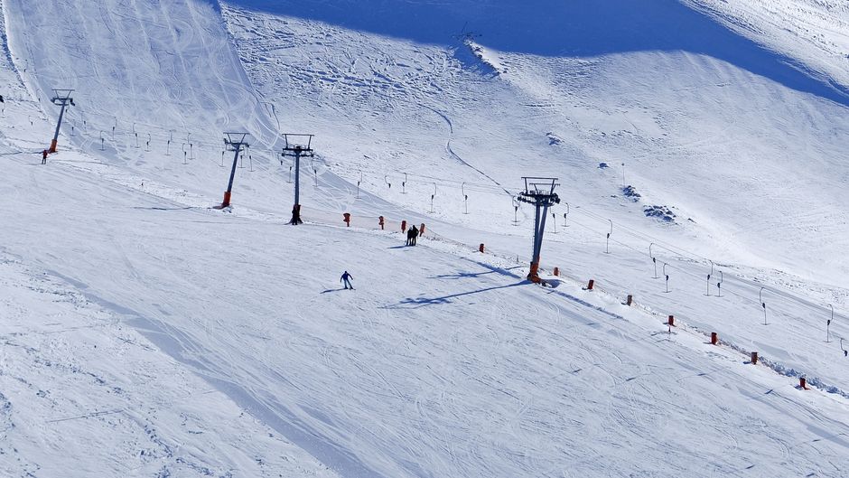 A vibrant scene of skiers and ski lift on snowy hills in Isparta, Türkiye.