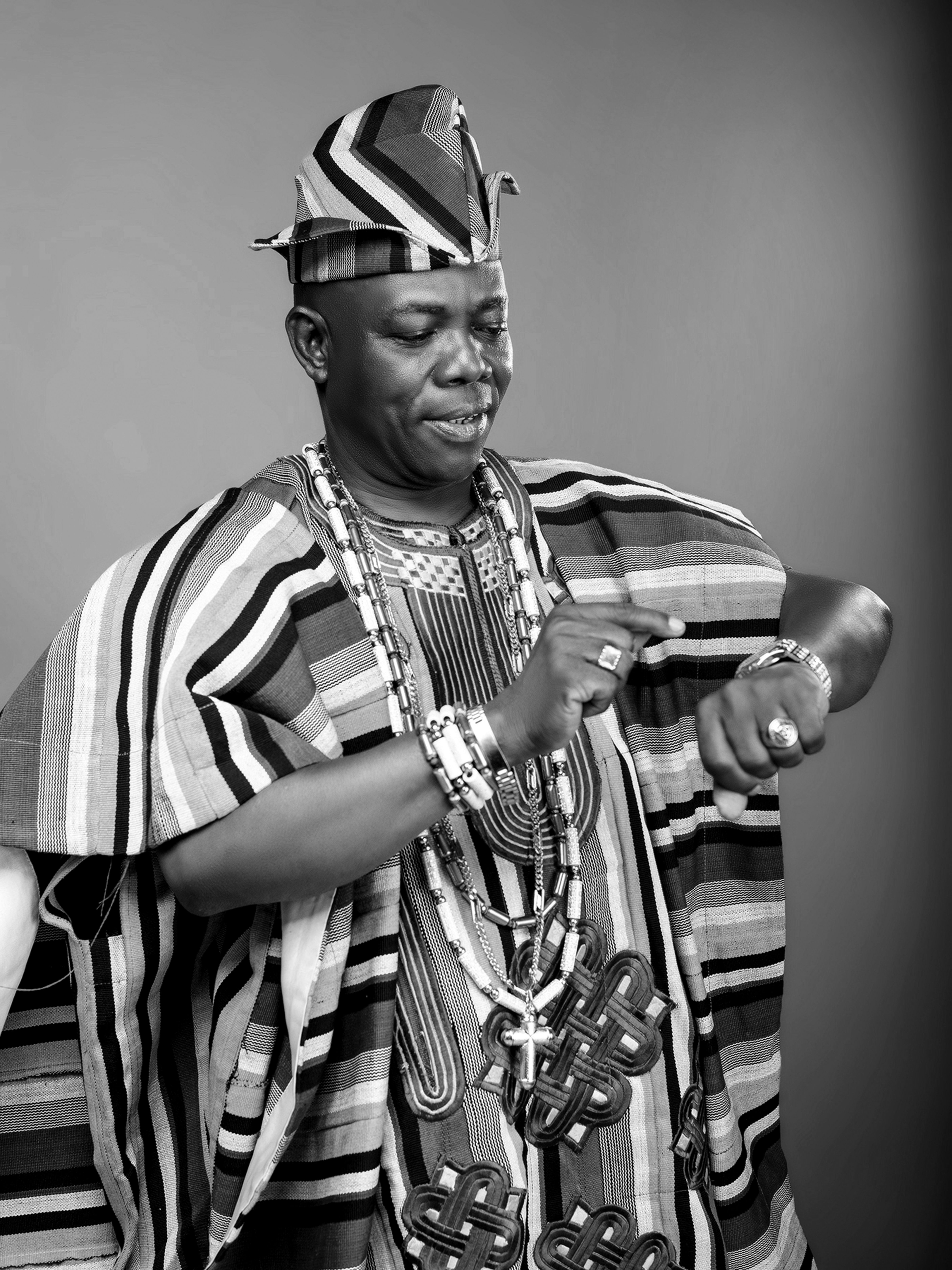 Black and white portrait of a man wearing traditional Yoruba attire, exuding cultural richness.