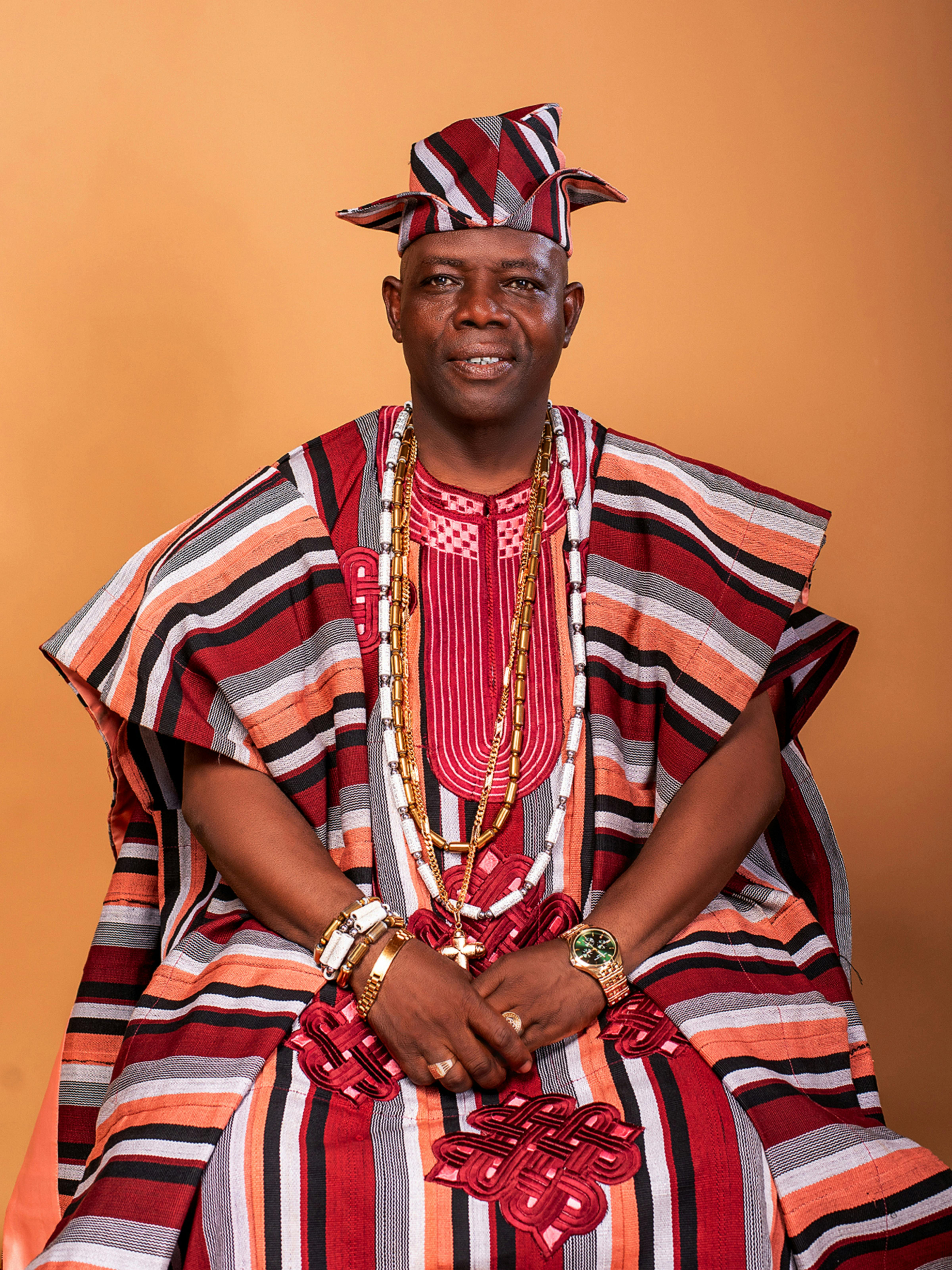 Adult man in vibrant Nigerian attire showcasing cultural heritage, studio portrait