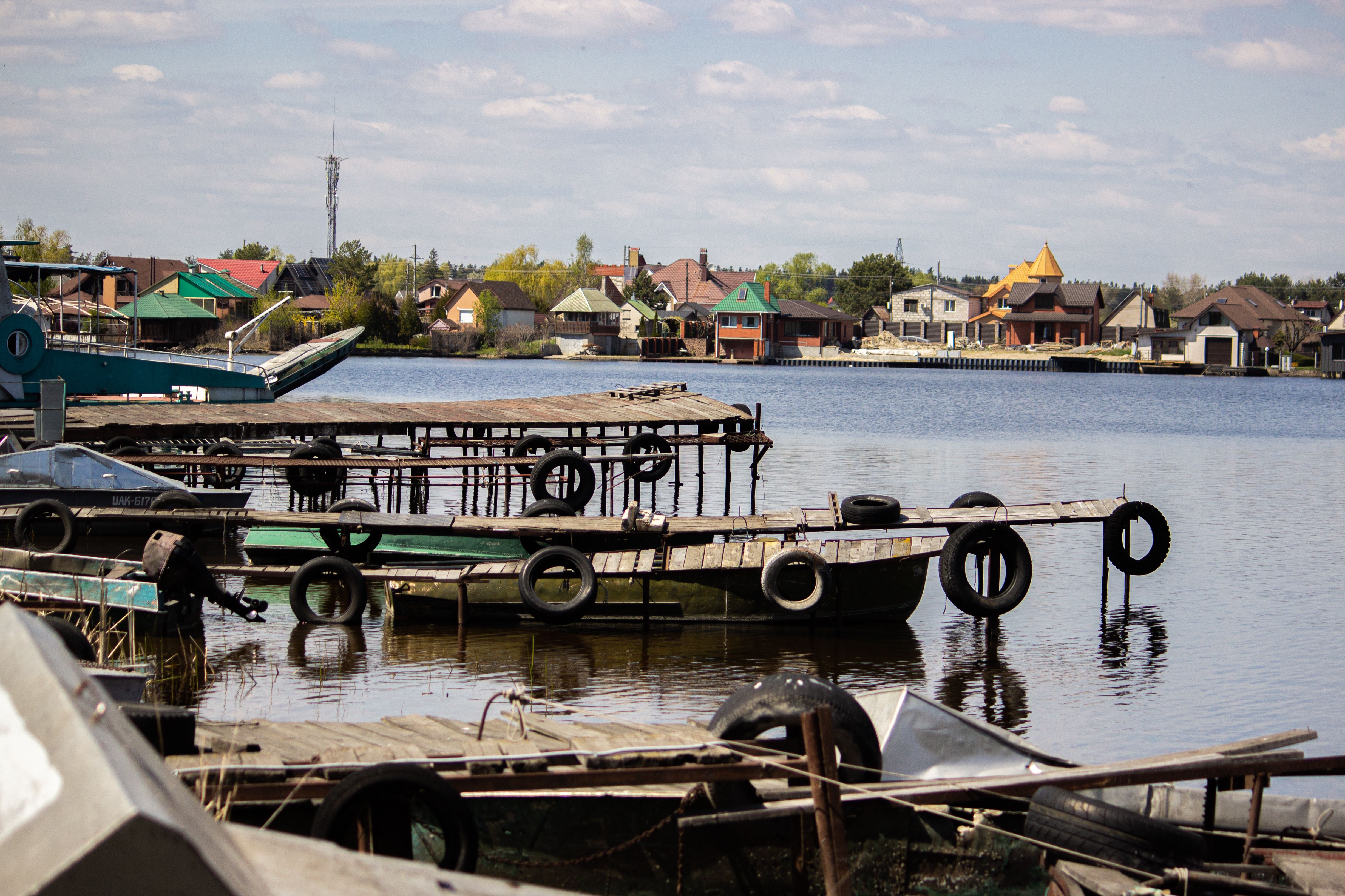 Tranquil dock scene on a serene lake with quaint village in the background.