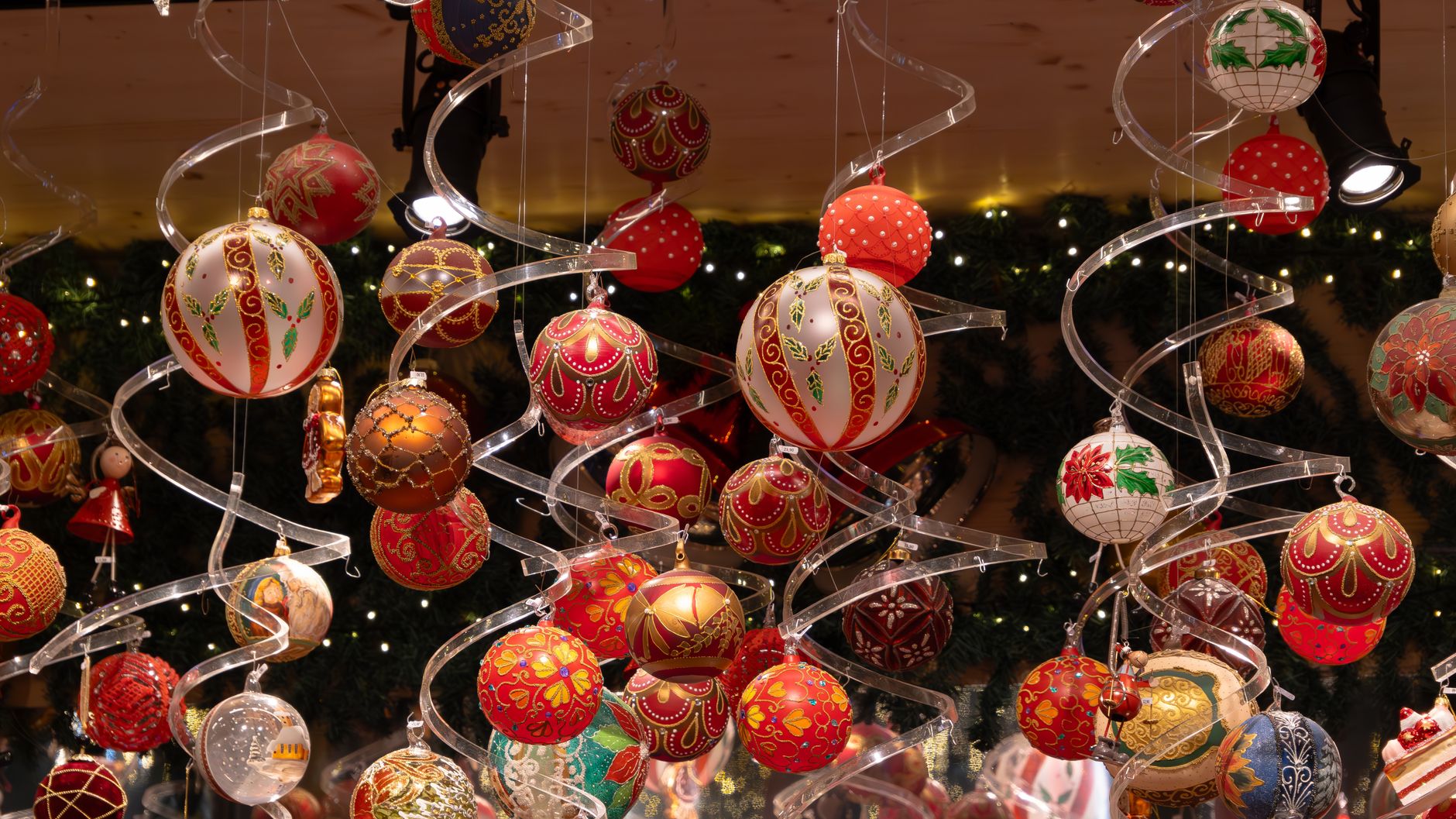 Hand-painted red and gold glass Christmas spheres hanging in a shop, the kind of Tlalpujahua Christmas spheres sold at the fair
