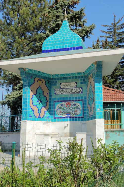 Free A turquoise tiled fountain structure outdoors with intricate patterns, trees, and clear sky. Stock Photo