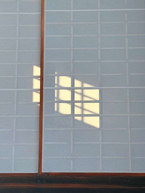 Free Japanese shoji panels with a window shadow creating a peaceful minimalist aesthetic. Stock Photo