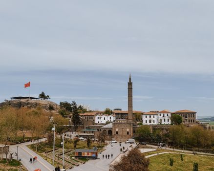 Discover the architectural splendor of Diyarbakır, featuring historic buildings and a Turkish flag under a clear sky.