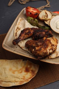 Delicious grilled chicken served on pita with vegetables and yogurt dip.