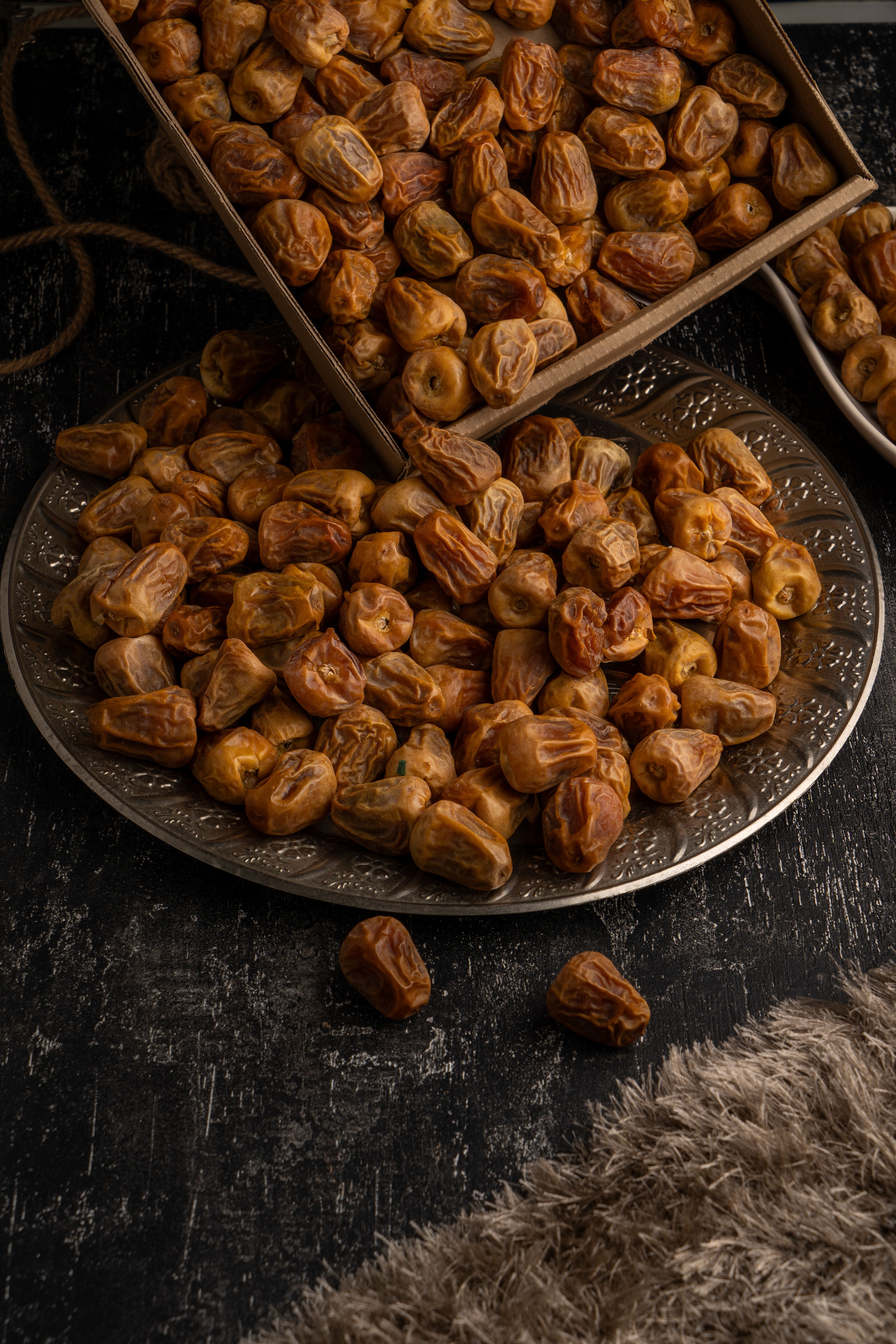 Dried dates on a wooden tray and platter, perfect for healthy eating and culinary themes.