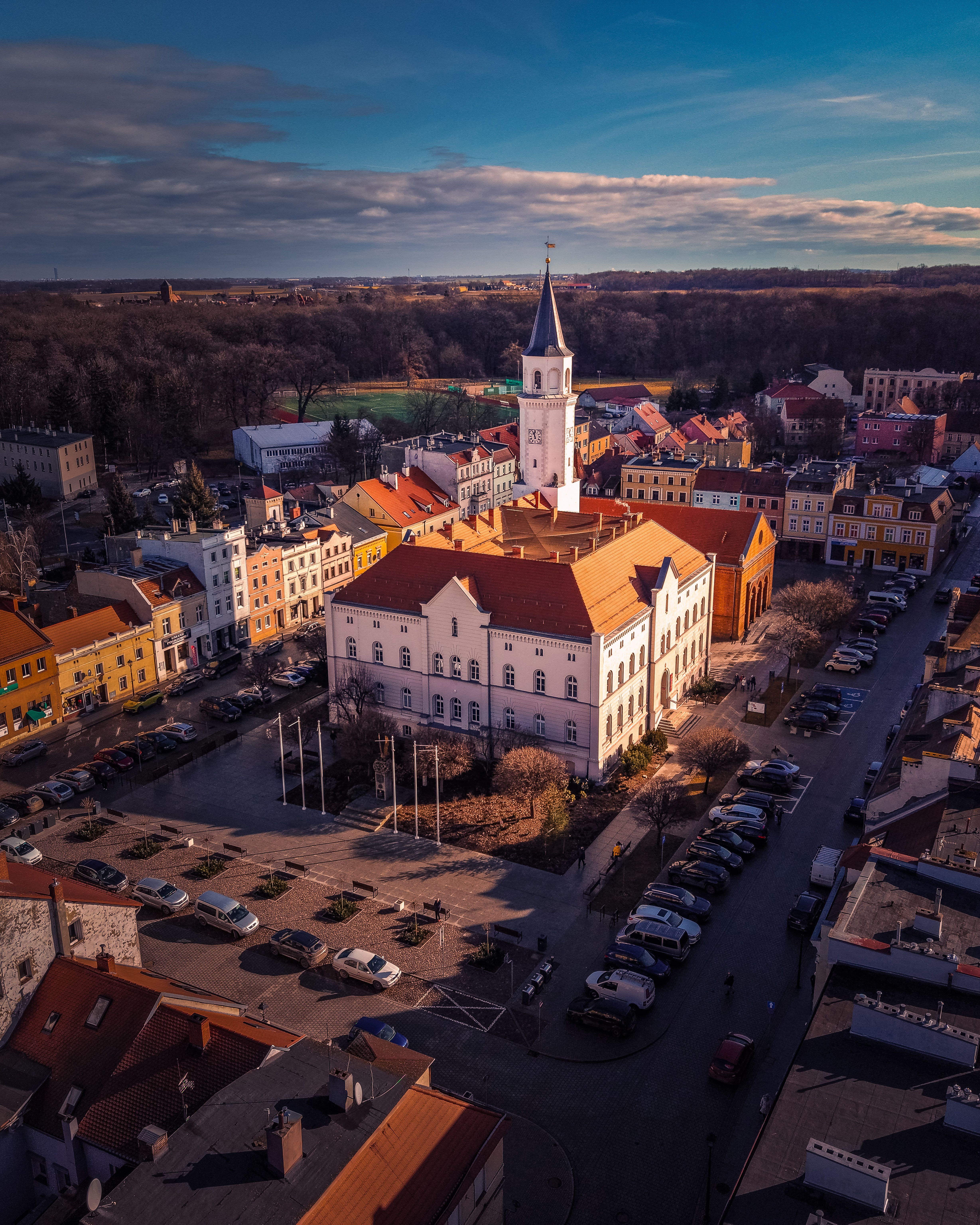 A captivating aerial view of a charming European town square with a central clock tower surrounded by colorful buildings.