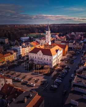 A captivating aerial view of a charming European town square with a central clock tower surrounded by colorful buildings.