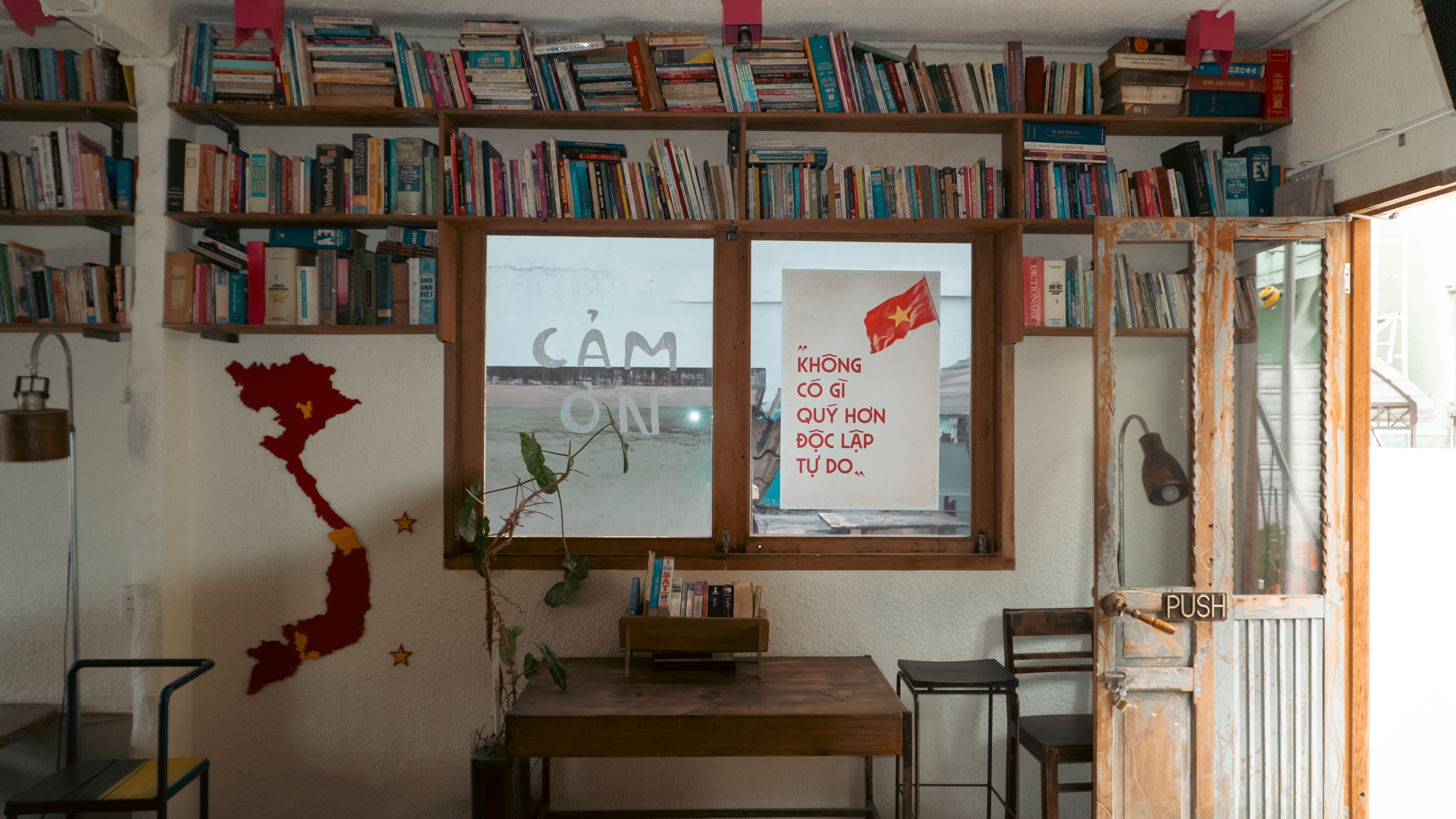 A cozy bookstore interior featuring Vietnamese decor and a map wall art.