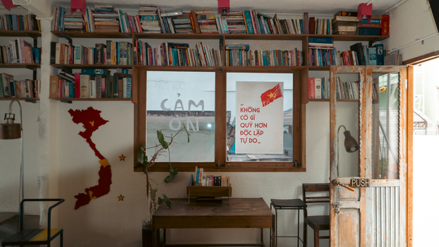A cozy bookstore interior featuring Vietnamese decor and a map wall art.