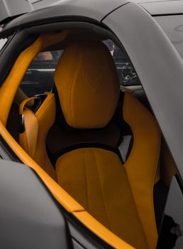 Close-up of a yellow leather seat in a luxury sports car, highlighting modern design.