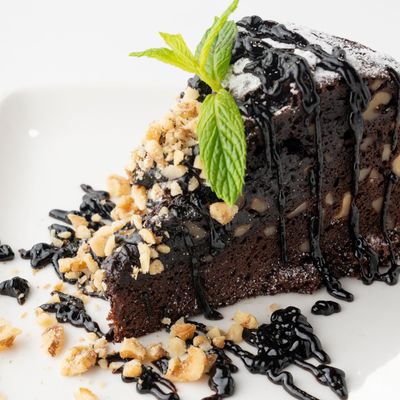 Rich layered chocolate cake slice on a plate — photo by Samed Bayrak on Pexels