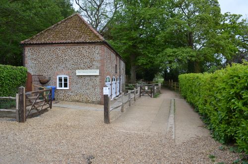 Free A historic watermill nestled in a lush green setting, offering a tranquil view of rural architecture and nature. Stock Photo