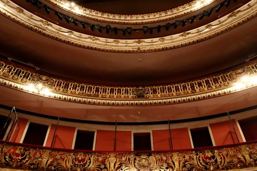 Free Richly decorated theater interior with gold details and dramatic lighting. Stock Photo