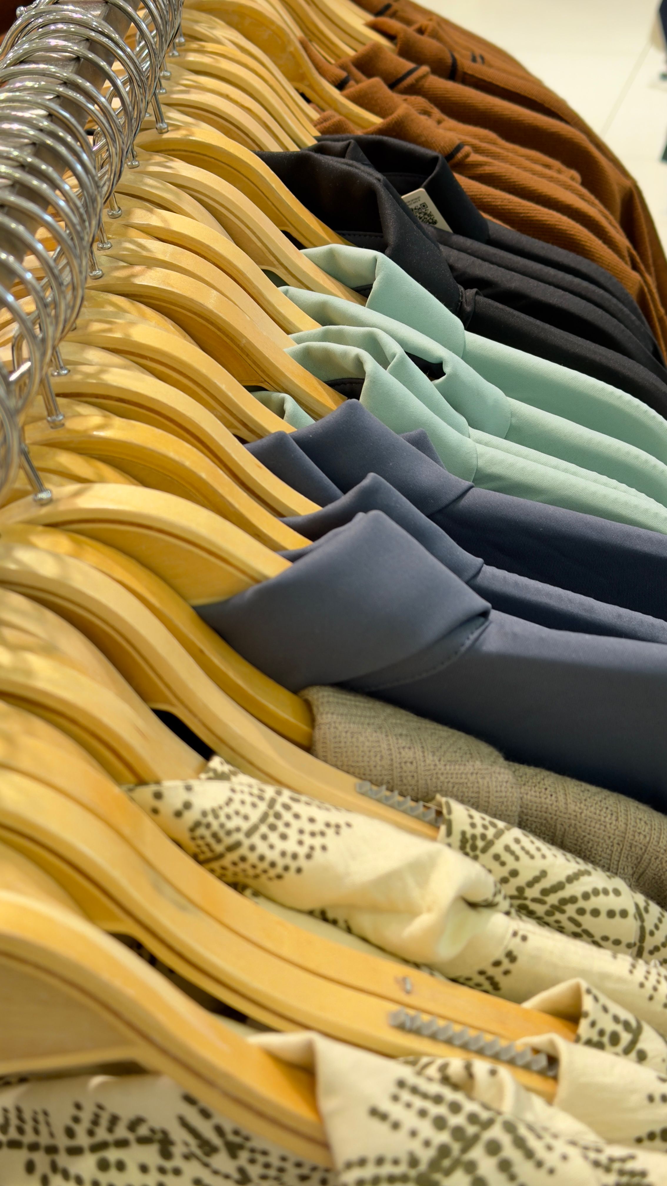 A stylish assortment of clothing on hangers showcasing various colors and materials.