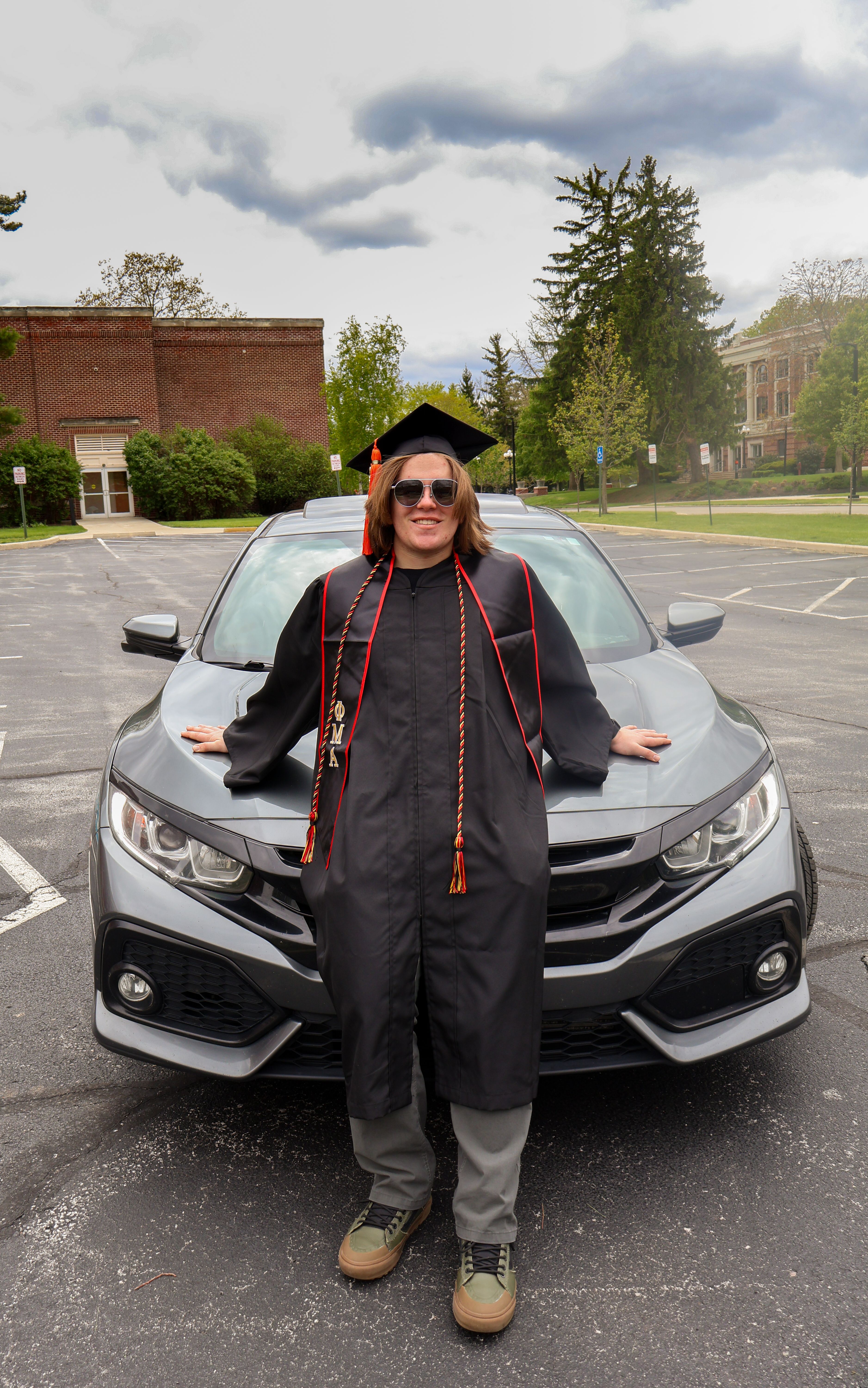 Graduating Student Poses with Car Outdoors · Free Stock Photo