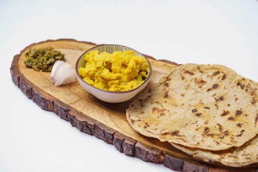 Close-up of Indian flatbread with lentil curry on a wooden platter, highlighting traditional cuisine.