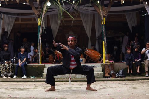Free Man performing traditional dance at cultural event with audience. Stock Photo