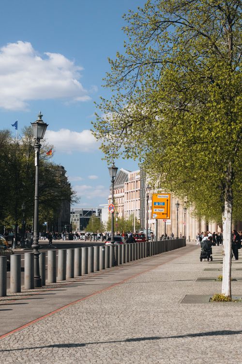 Free Vibrant street scene in Berlin on a sunny day, showcasing urban architecture and lively pedestrian activity. Stock Photo