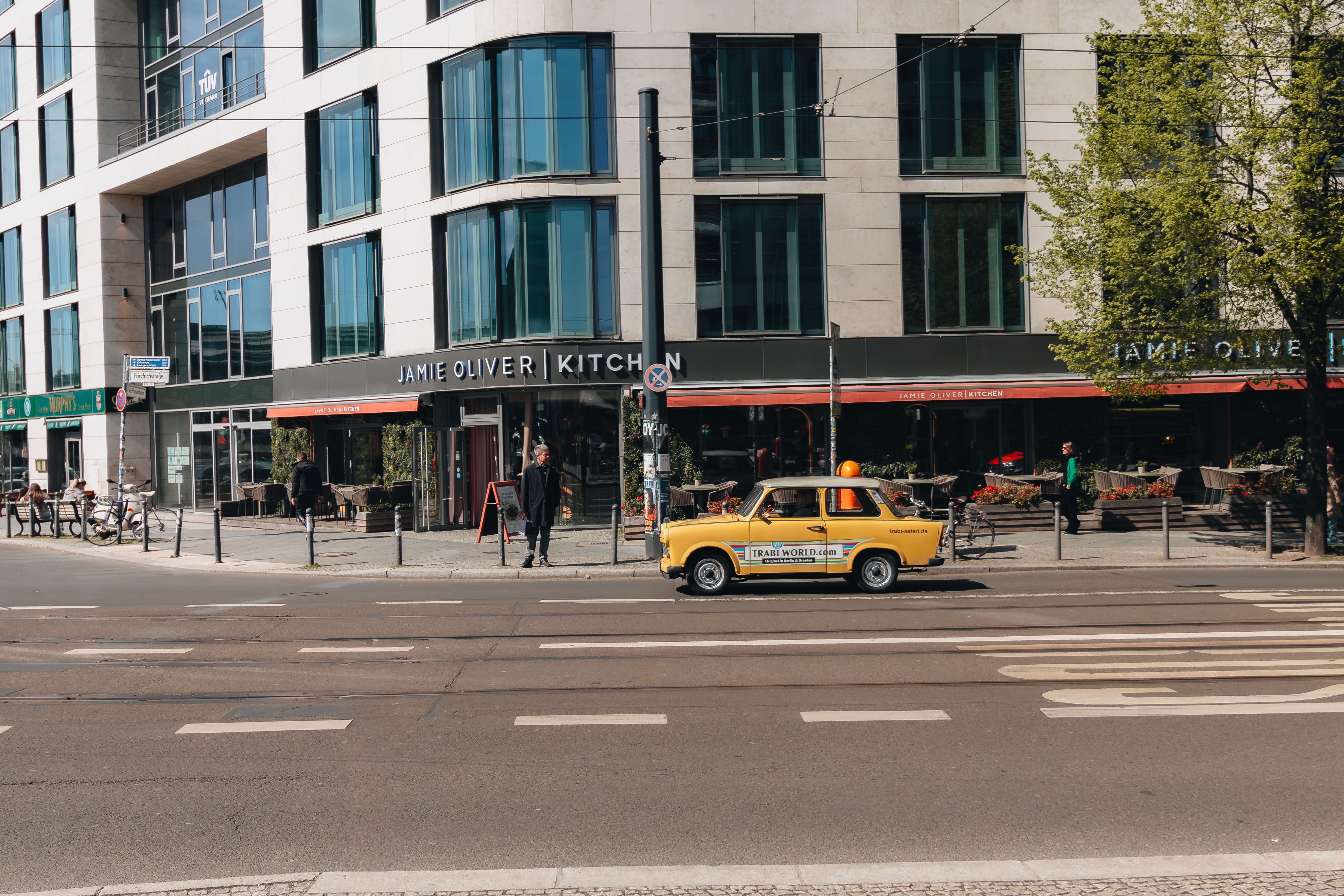 Yellow car in front of Jamie Oliver Kitchen on a sunny day in Berlin, Germany.