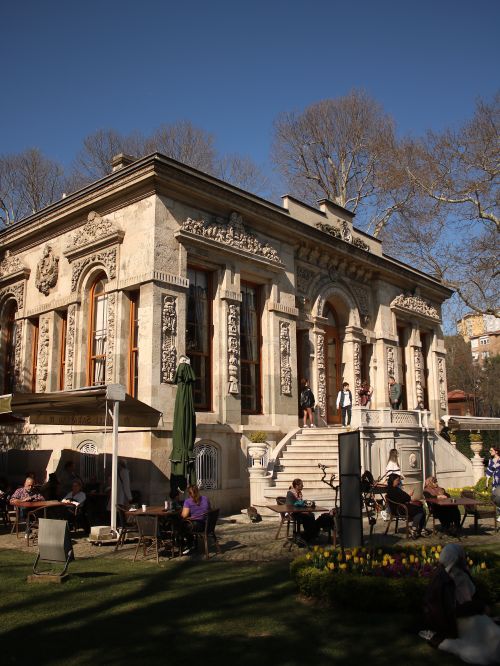 Free Historic Ottoman palace in Istanbul with tourists in a lush outdoor garden setting under a clear sky. Stock Photo