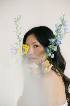 A serene portrait of a woman surrounded by vibrant wildflowers, exuding a natural and ethereal charm.