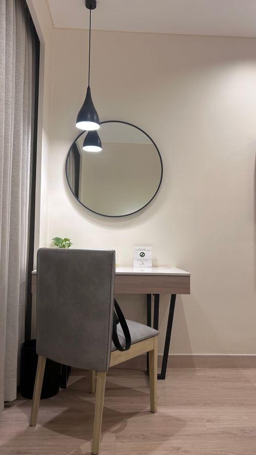 Free Sleek modern desk with circular mirror and pendant light in a minimalist style room. Stock Photo