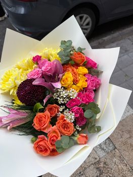 Colorful flower bouquet featuring roses, chrysanthemums, and lilies, wrapped elegantly.
