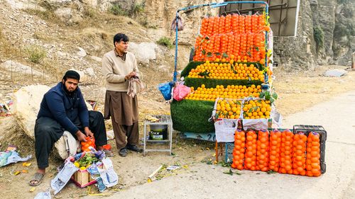 Free Colorful fruit stall on roadside in Ghalegay, Pakistan, showcasing fresh oranges and rural life. Stock Photo