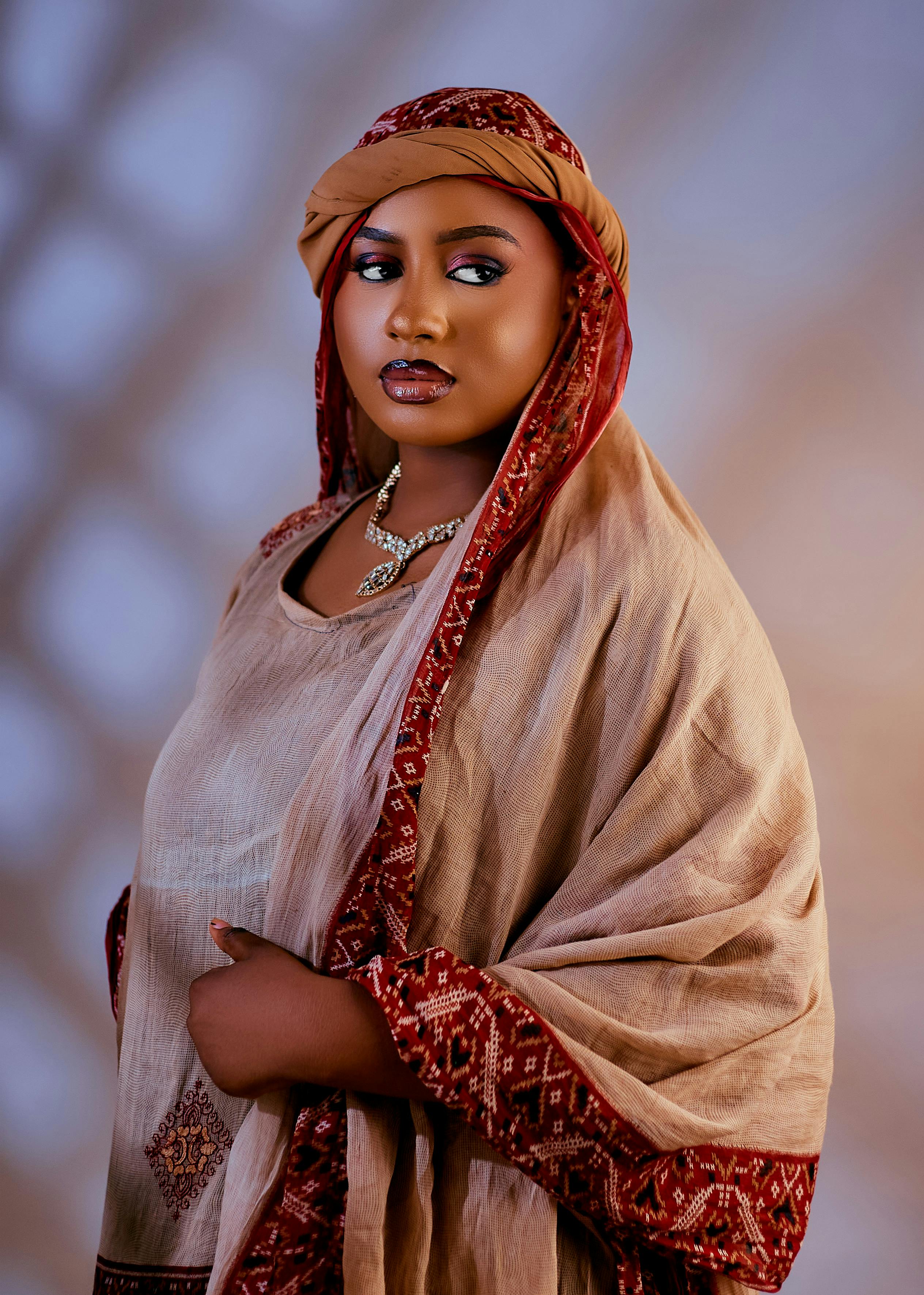 Portrait of an adult woman in traditional attire with intricate patterns and a calm expression.