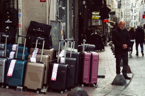 Free A man stands beside a colorful display of luggage on a bustling street in Istanbul, Turkey. Stock Photo