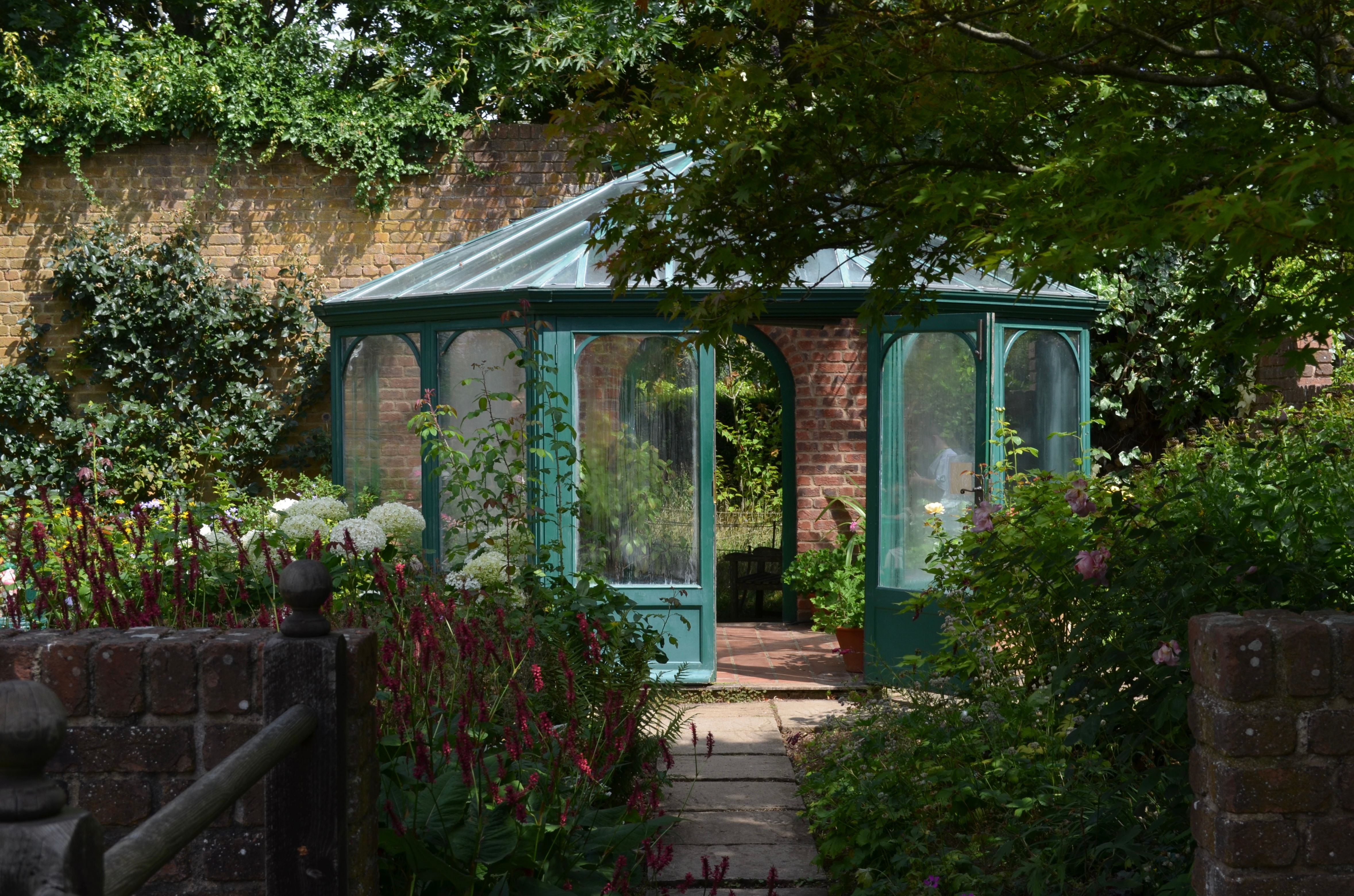 A picturesque garden gazebo encircled by vibrant plants and flowers, perfect for relaxation.