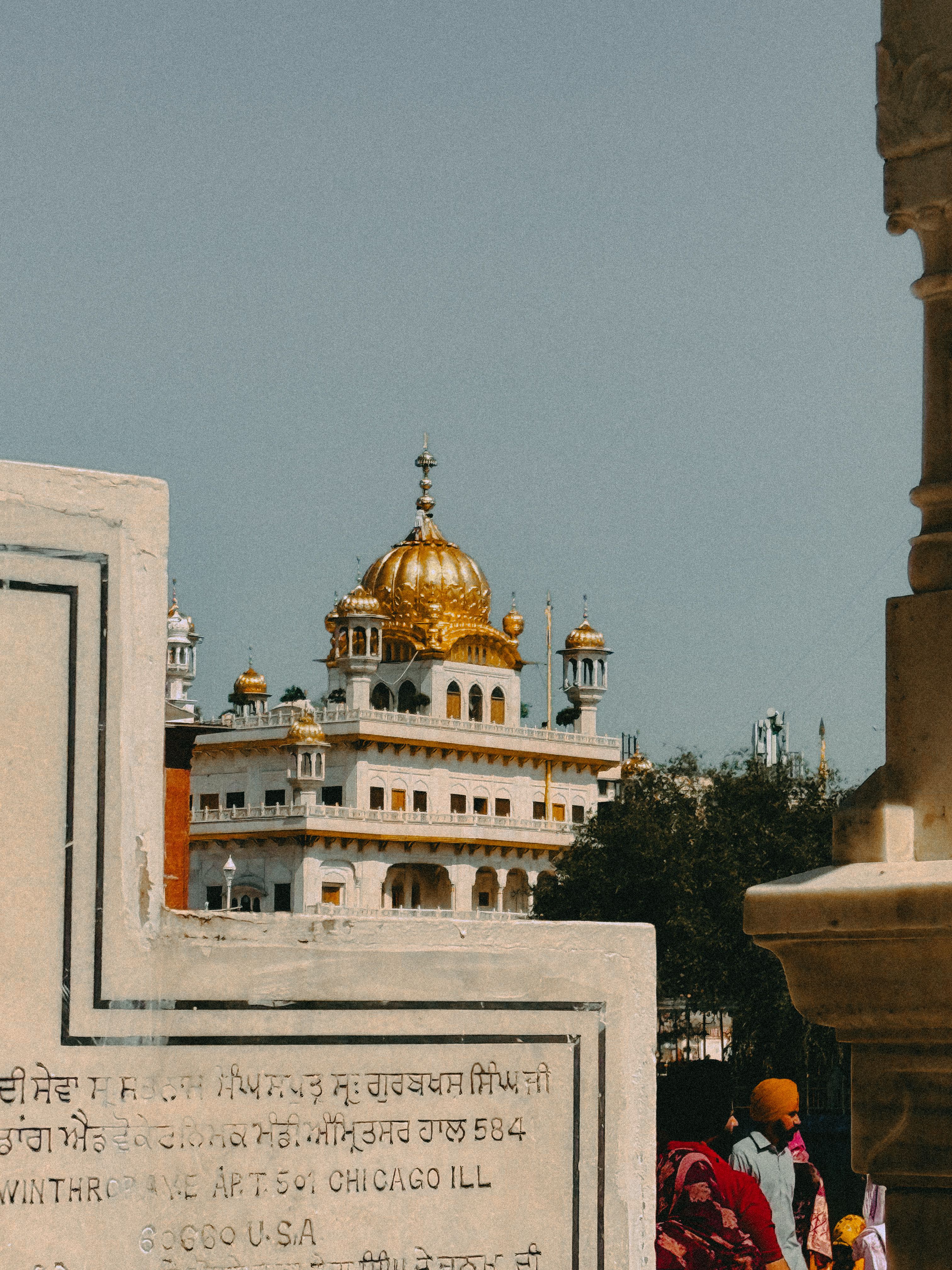 The beautiful golden dome of a temple in Amritsar, Punjab, visible through surrounding architecture.