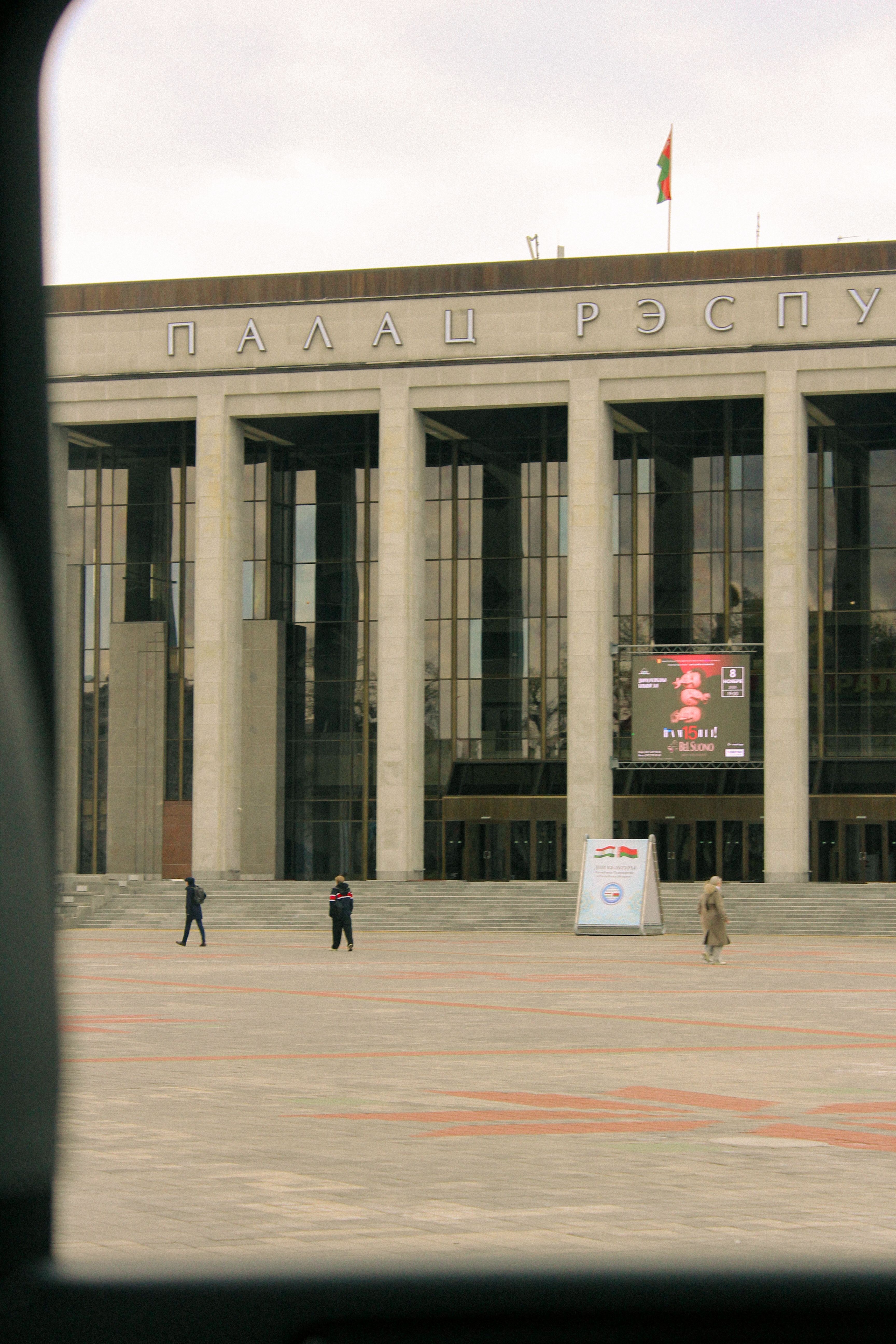 The Palace of Republic in Minsk, Belarus captured from the front showing people walking by the landmark.