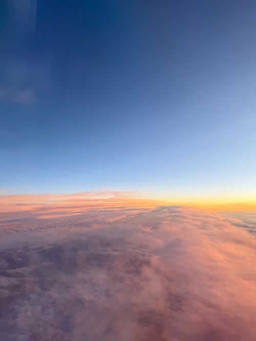 Free A breathtaking aerial view of a sunset over clouds with a vibrant sky. Stock Photo