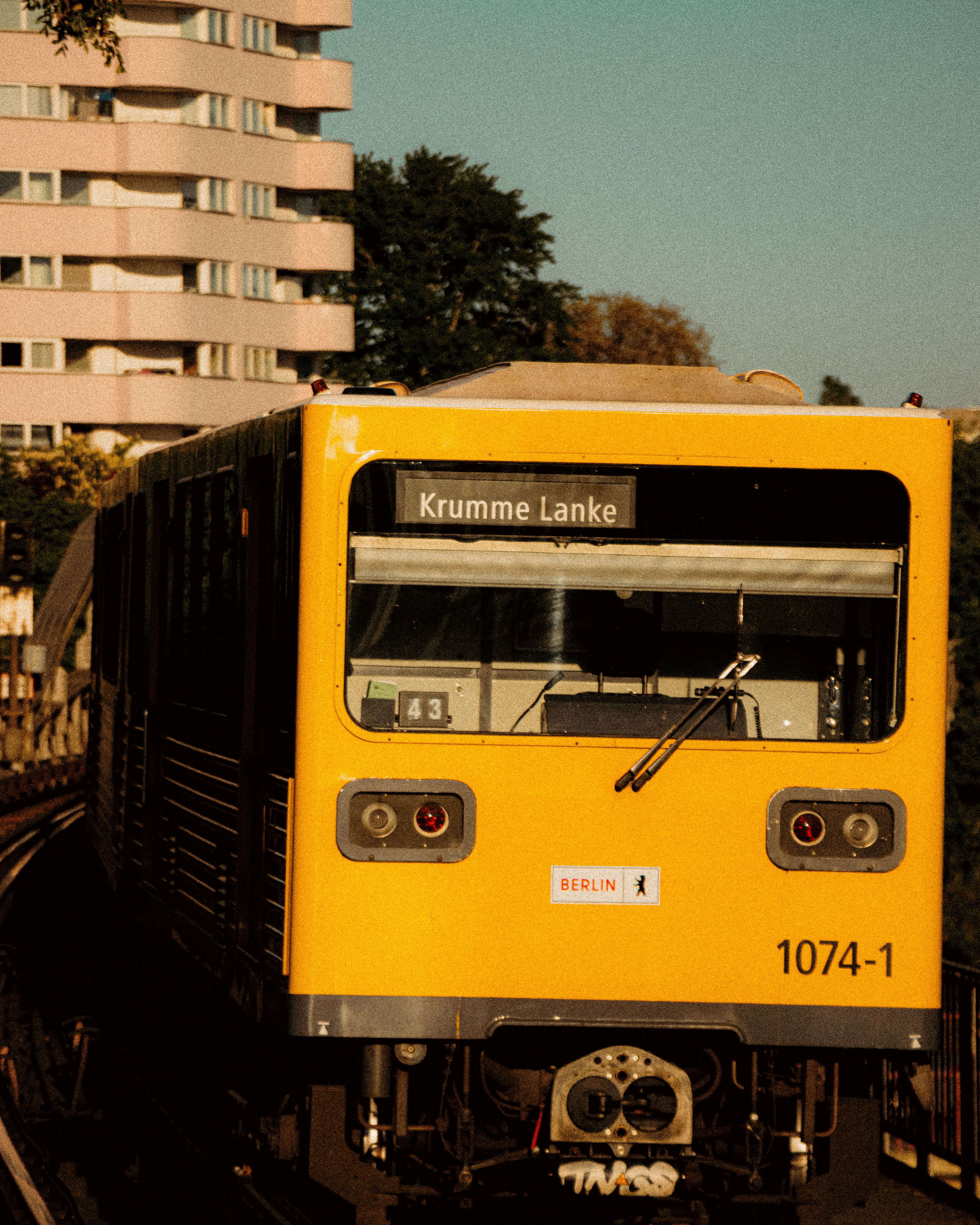 Iconic yellow U-Bahn train at sunset, Berlin's Krumme Lanke station.
