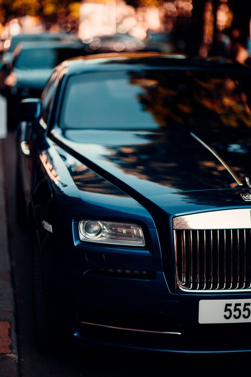 Free Close-up of a sleek blue luxury car parked on a city street Stock Photo