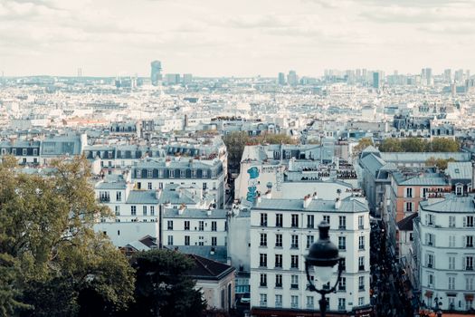 Aerial view of Parisian rooftops showcasing classic architecture under a bright sky.