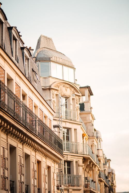 Free Elegant Parisian buildings with classic architecture under a warm sunset glow. Stock Photo