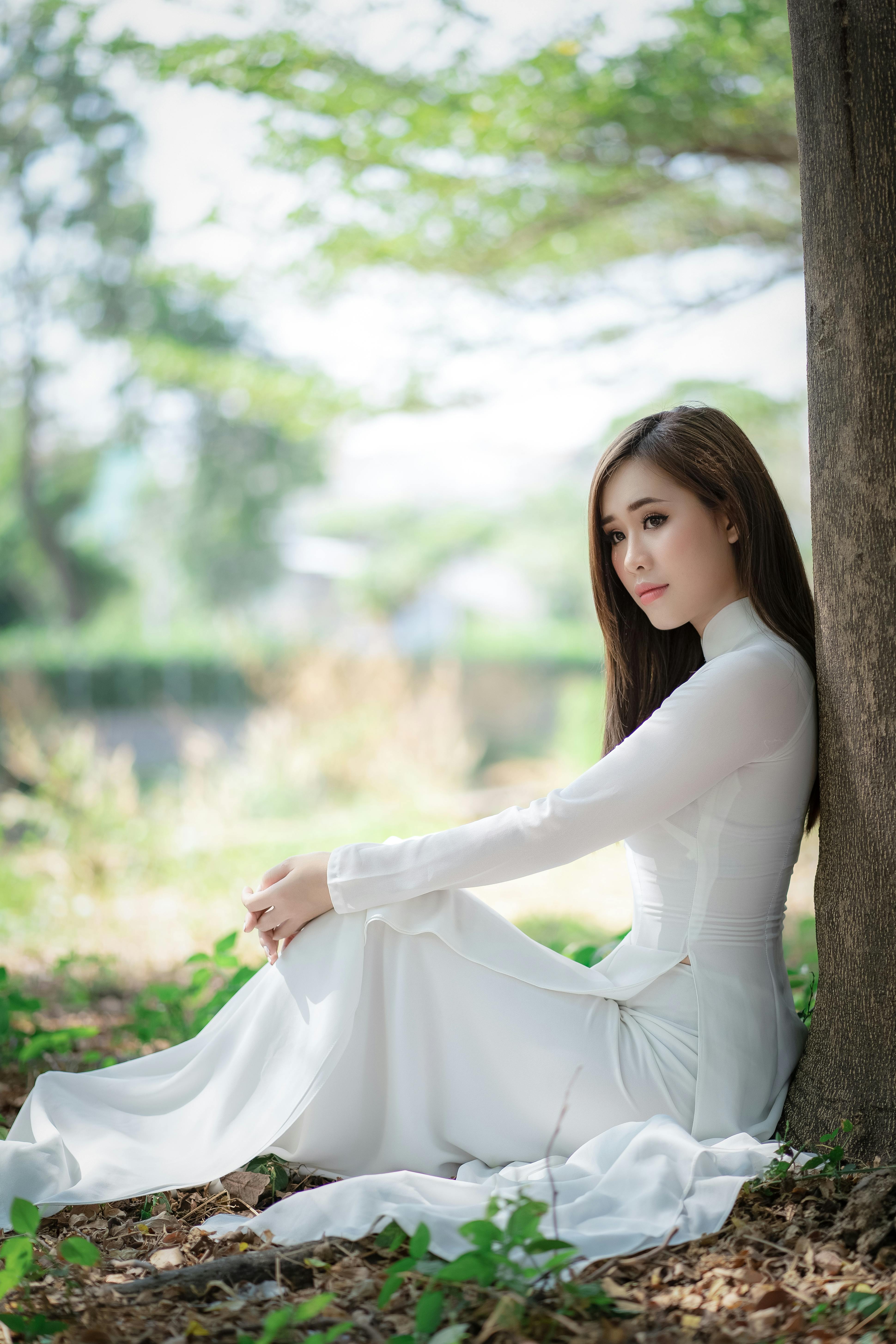 dreamy sensual woman in bridal dress under tree