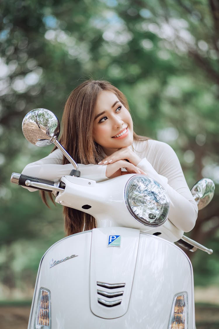 Charming Asian Woman On Scooter In Park