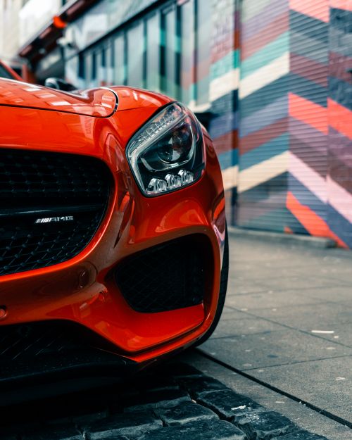 Free Close-up of a shiny red sports car parked by a vibrant graffiti wall in Dresden, Germany. Stock Photo