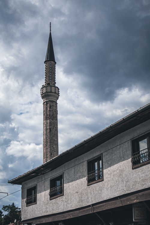 Free A striking minaret rises against dramatic clouds in Sarajevo, showcasing Ottoman architecture. Stock Photo