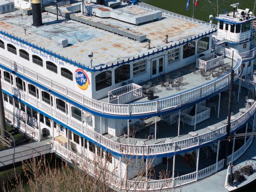 Free A classic paddlewheel riverboat moored at Chattanooga, showcasing its multi-deck structure during a sunny day. Stock Photo