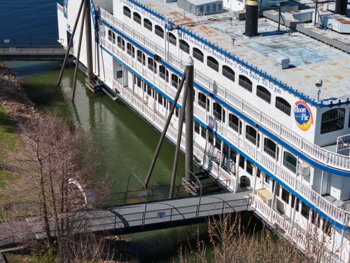 Free Aerial view of Southern Belle Riverboat docked near riverbank with clear water and blue sky. Stock Photo