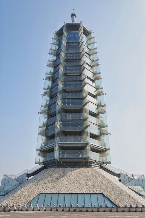 Free A tall, glass-panelled tower with modern architecture reaching into a clear blue sky. Stock Photo
